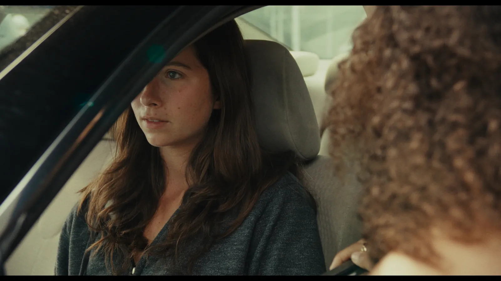 Perfect Love still — a woman in the passenger seat of a car
