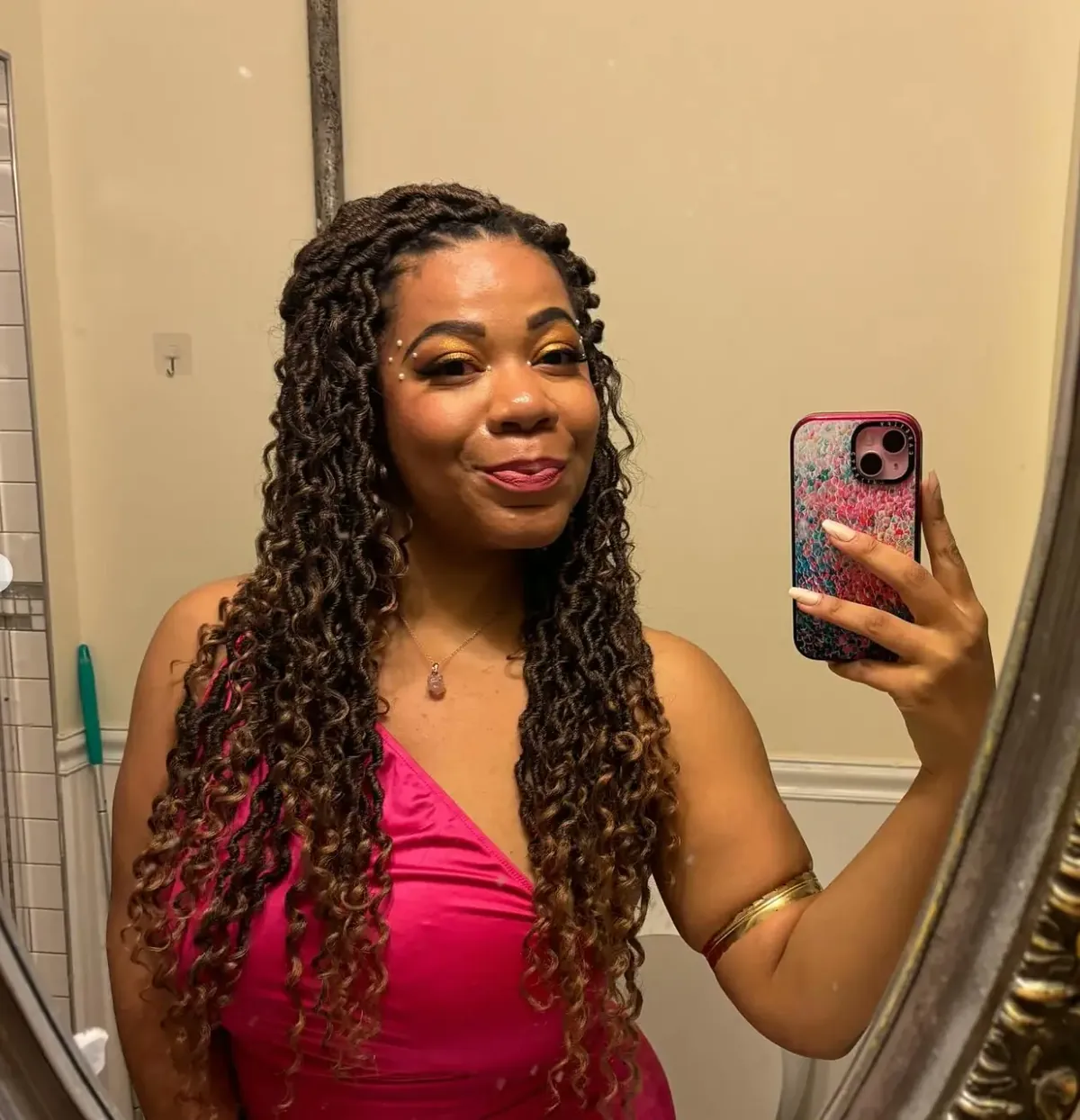 Behind the scenes on Divine Intervention — actor in a pink dress taking a mirror selfie