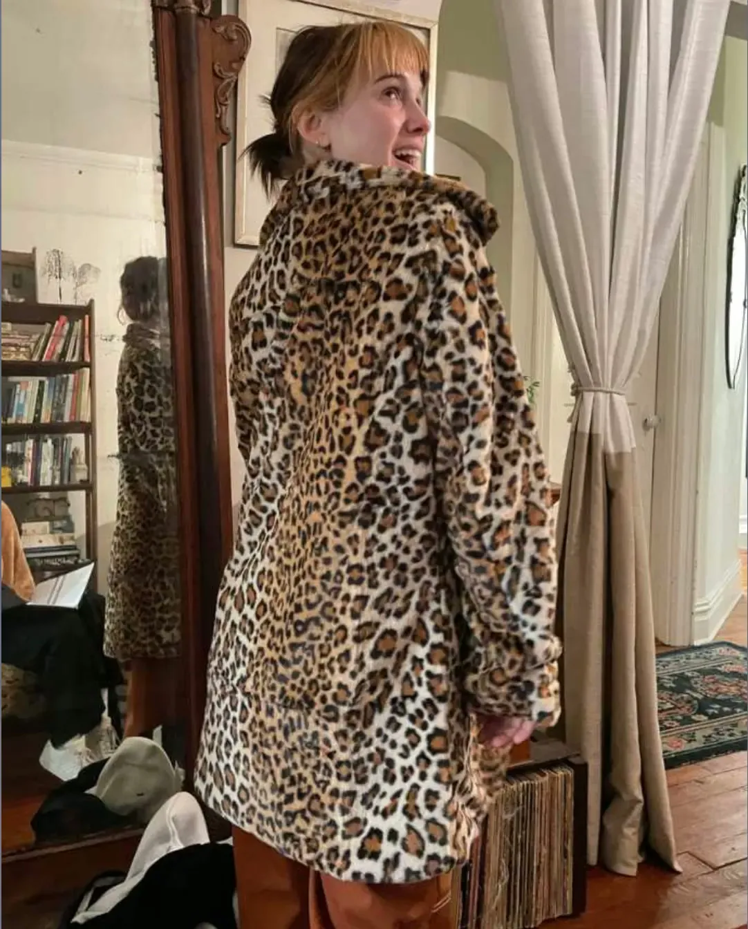 Behind the scenes on Divine Intervention — actor in a leopard-print coat by a mirror