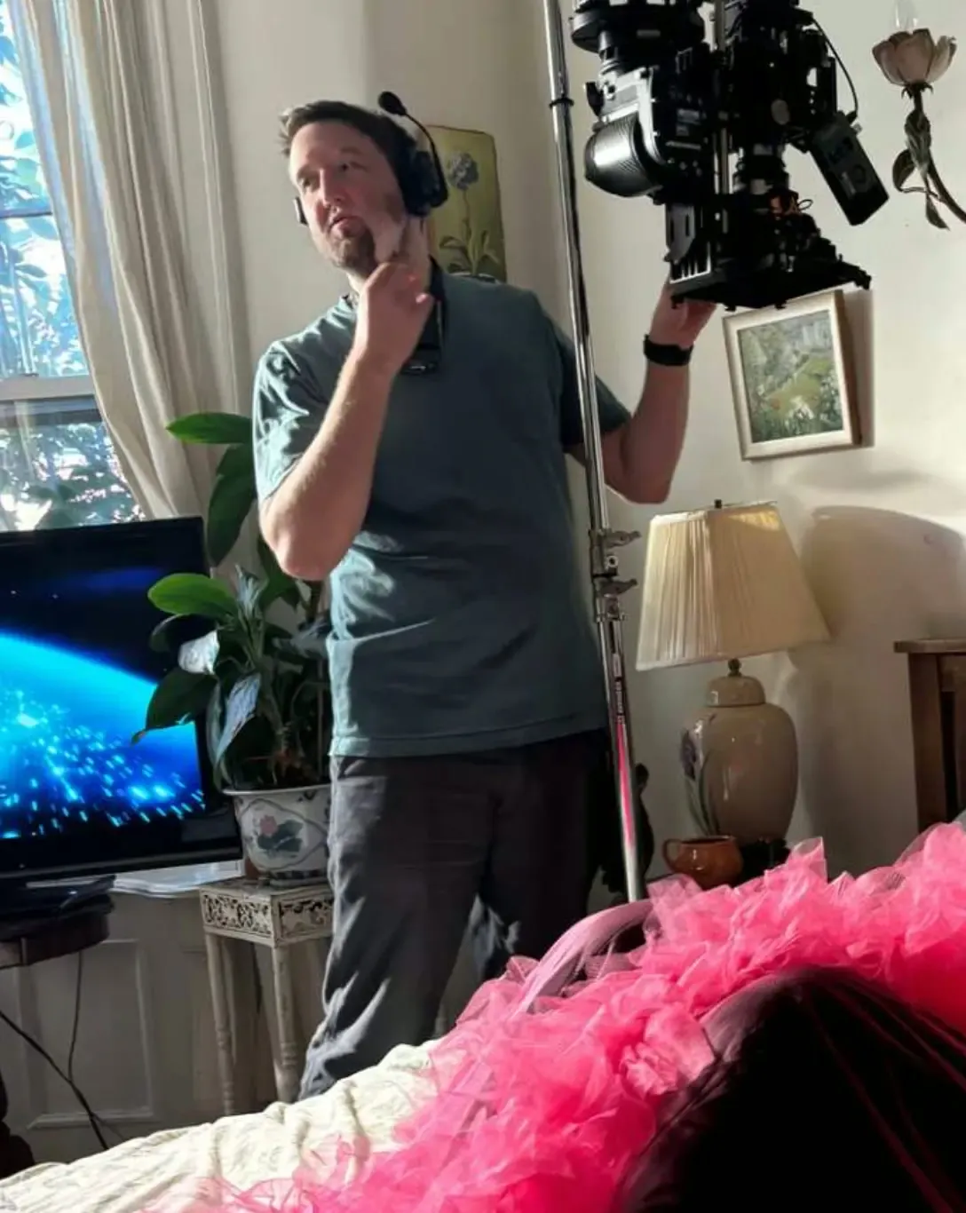 Behind the scenes on Divine Intervention — camera operator with a rig over a pink-tulle bed